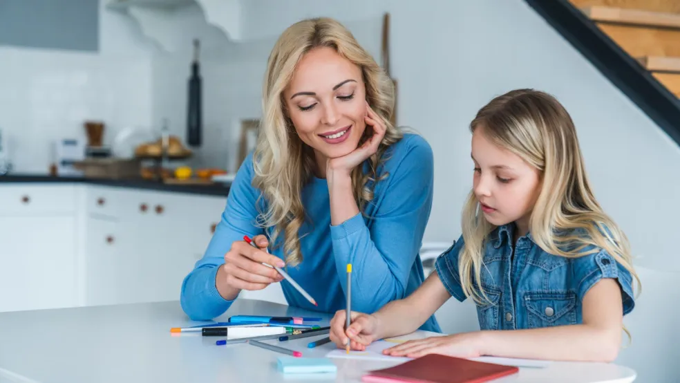 Mama pomáha dcére pri domácej úlohe a spoločne kontrolujú napísané cvičenie