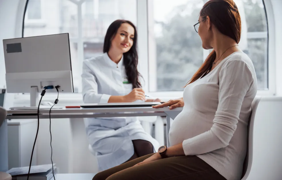 Tehotná žena počas konzultácie s gynekologičkou o priebehu tehotenstva a výsledkoch prenatálnych vyšetrení